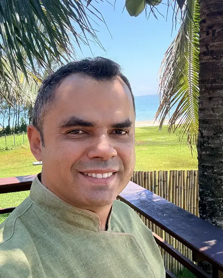 Joel Pinheiro, consultor gastronômico, de dólmã verde com a sua marca bordada, à beira-mar