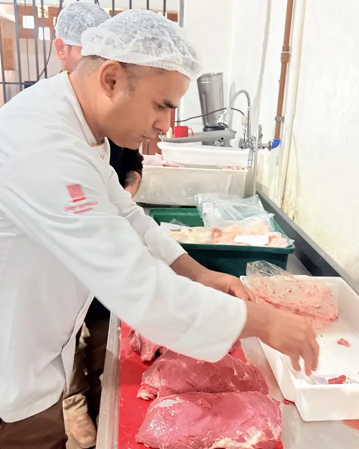 Joel Pinheiro porcionando carnes na cozinha, etapa da ficha técnica e do controle de custos